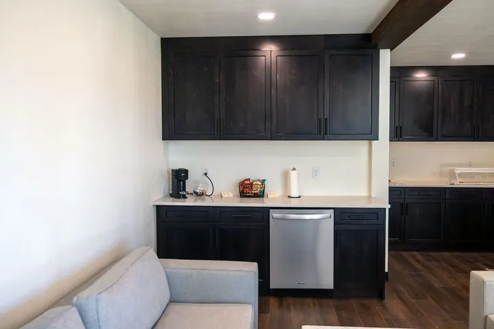 Container kitchenette with dark shaker cabinets, quartz countertop and built-in dishwasher