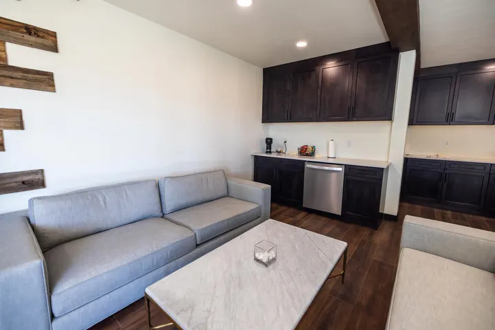 Container office lounge with sofa, marble coffee table and dark wood kitchenette cabinets