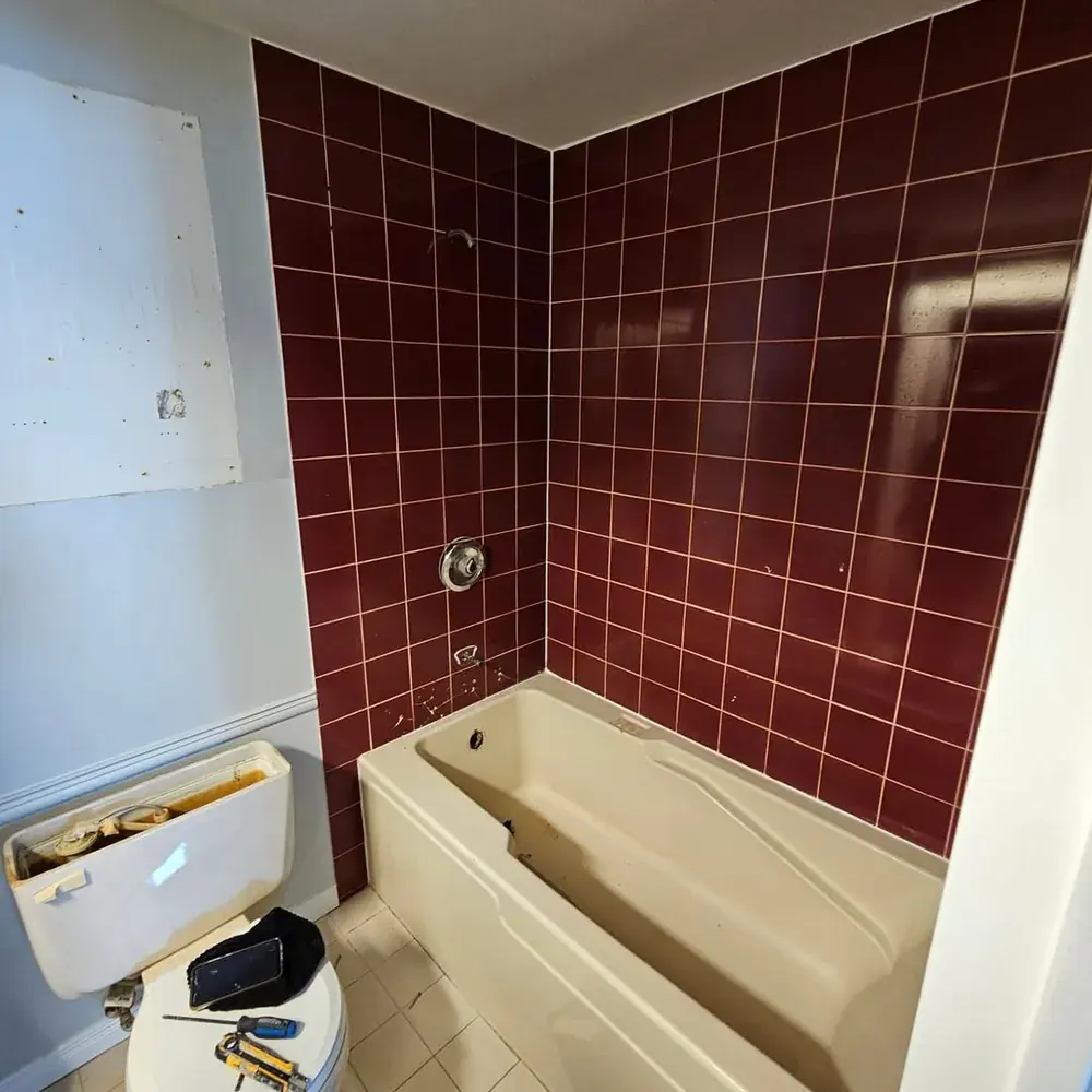 Original maroon ceramic tile tub and shower surround before remodel