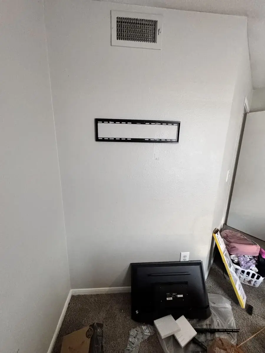 TV wall mount bracket installed with TV waiting on the floor, before final hang