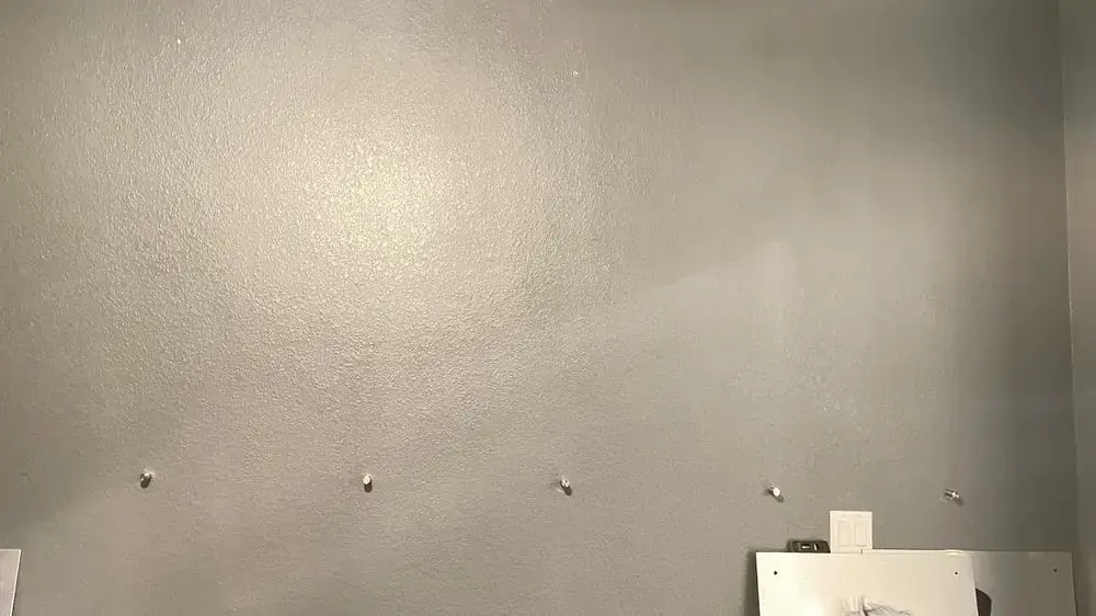 Blank hallway wall with mounting anchors pre-placed in an even row, before art panel install