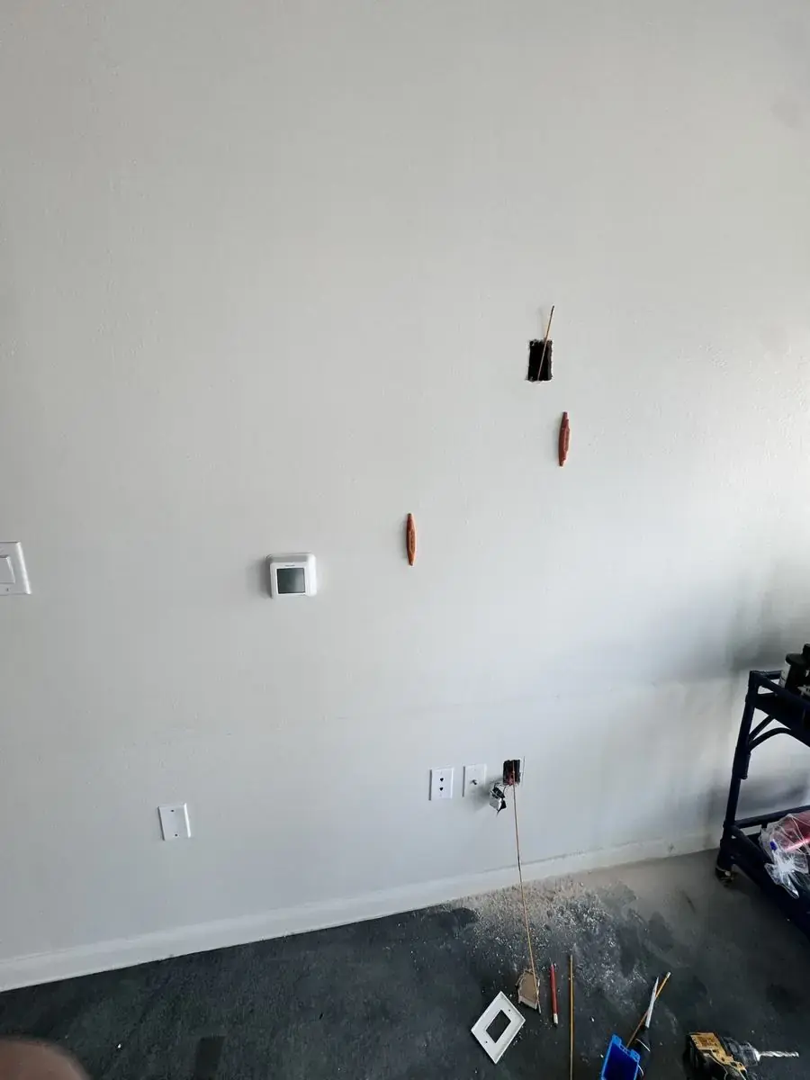 Wall with wire pulled through and outlet box prepped, before TV mount