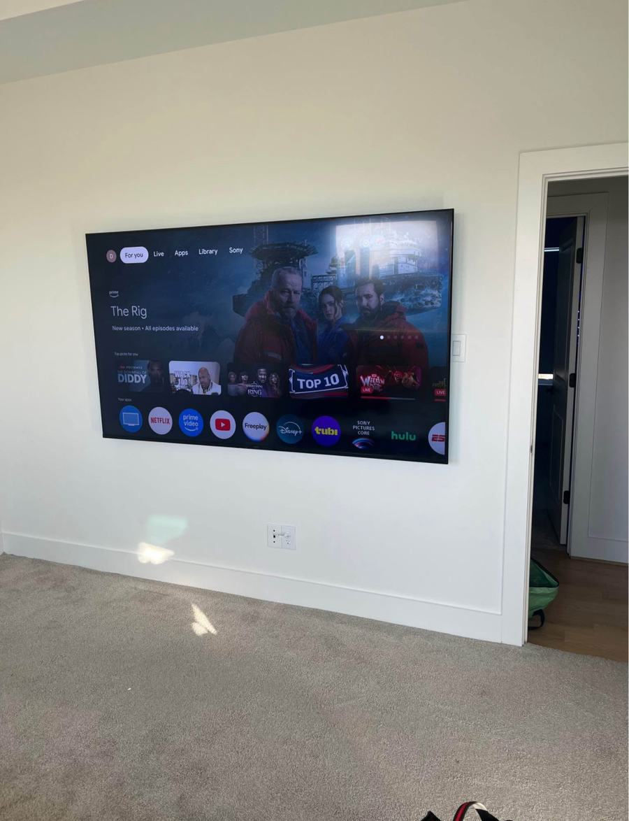 Large TV mounted level and centered in a South Austin living room