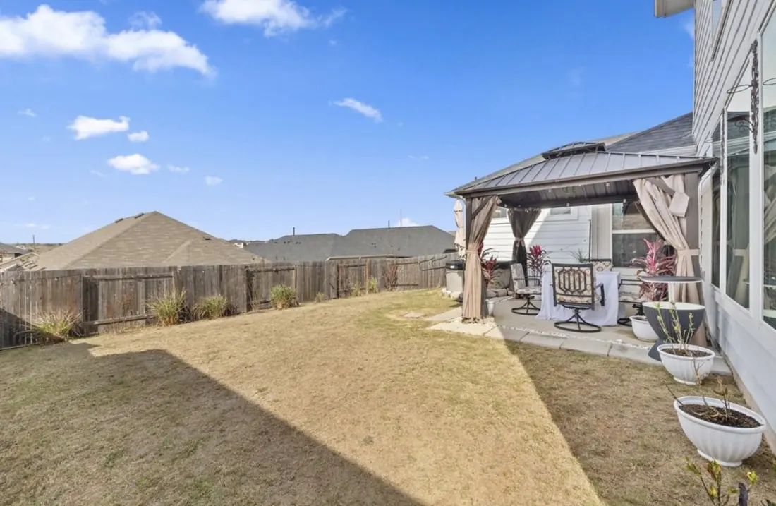 Backyard patio with a canopy gazebo and outdoor seating