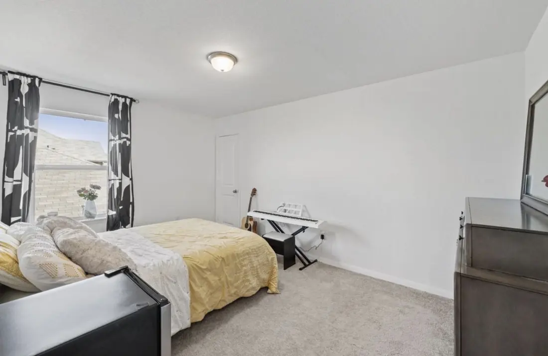 Bedroom with room for a small music setup by the window