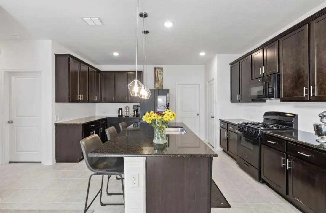 Kitchen with dark cabinetry and granite counters