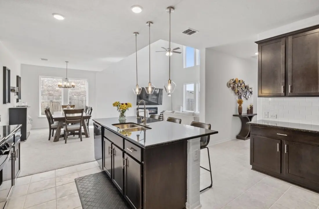 Kitchen island with granite countertop and pendant lighting, open to the dining area