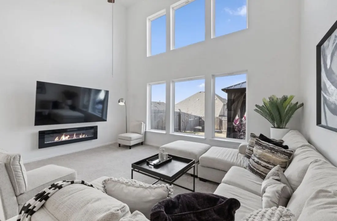 Living room seating area with a neutral sectional sofa and tall windows