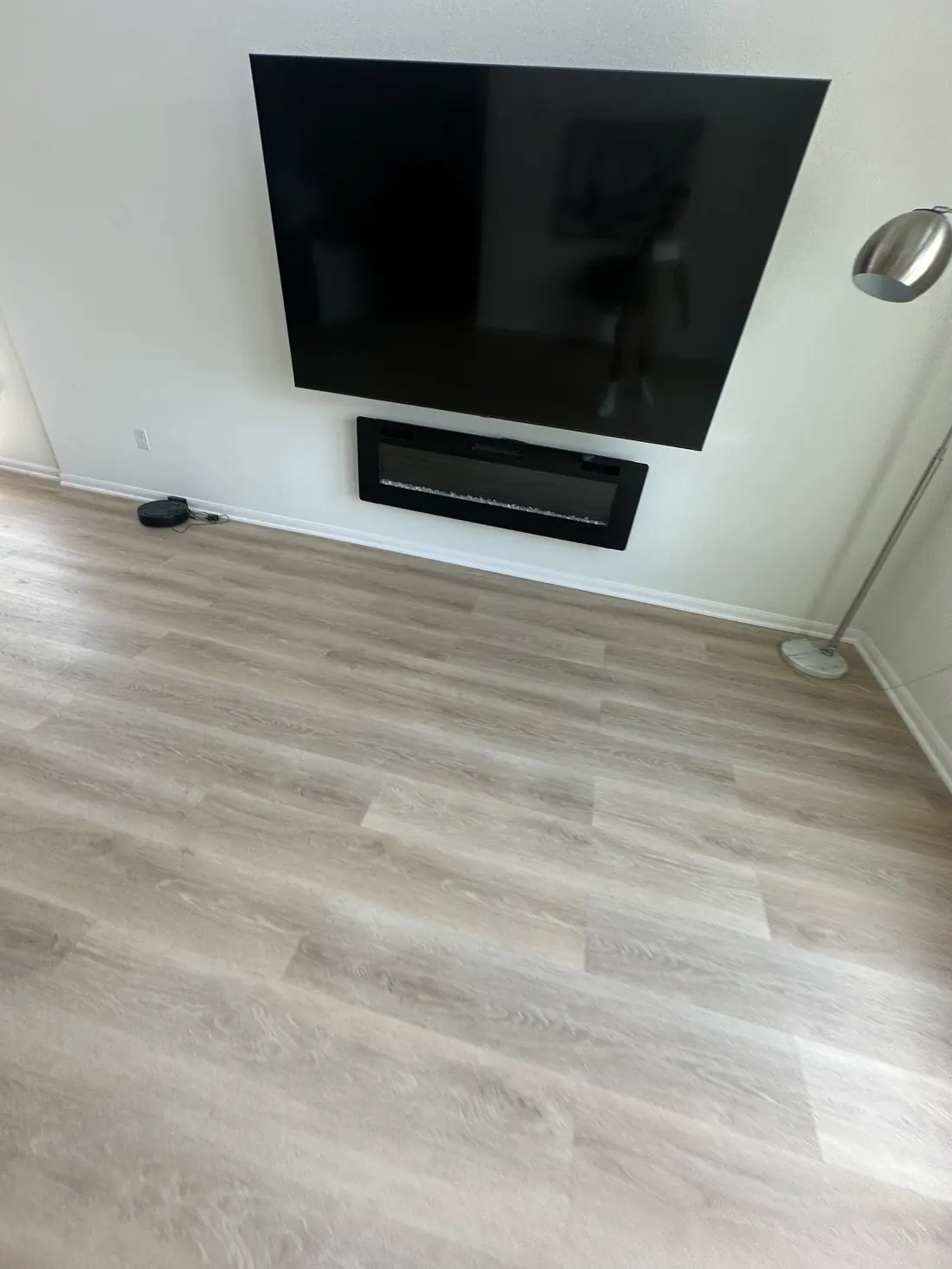Living room new flooring below the wall-mounted TV and electric fireplace