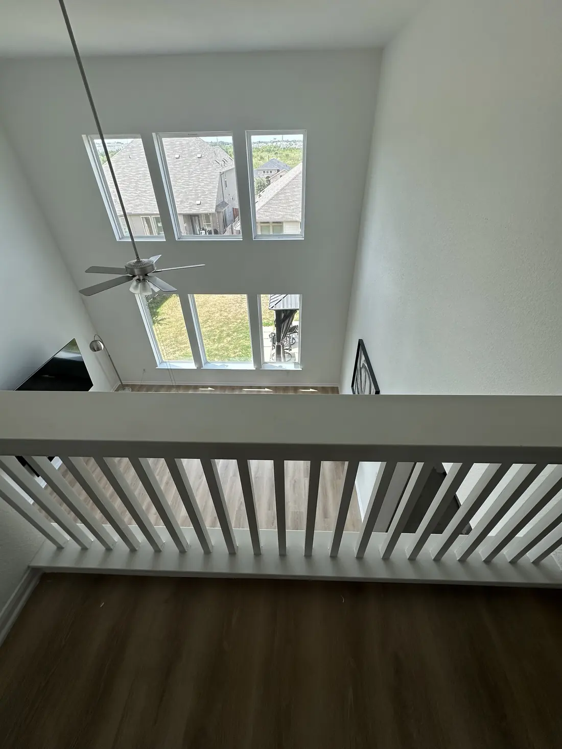 View down from the second-floor loft railing over the new flooring in the living room below