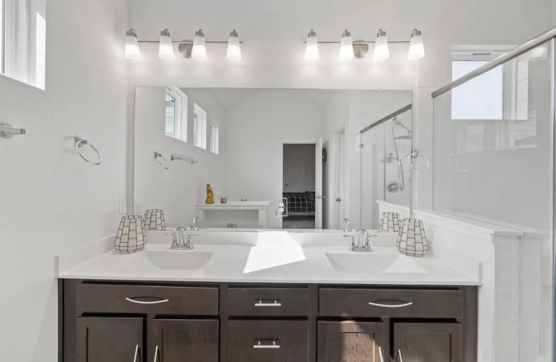 Secondary bathroom with double vanity and glass-enclosed shower