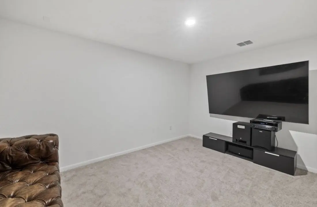 Theater room with a mounted TV and sound system