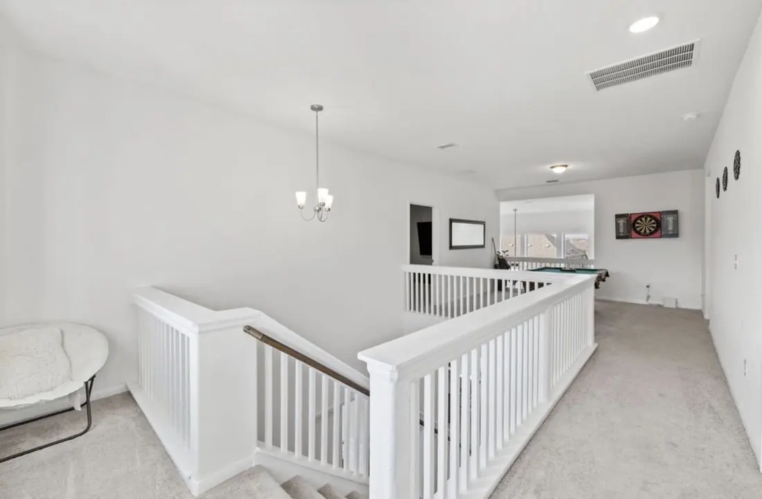 Upstairs landing with a railing overlooking the stairs, opening into the game room