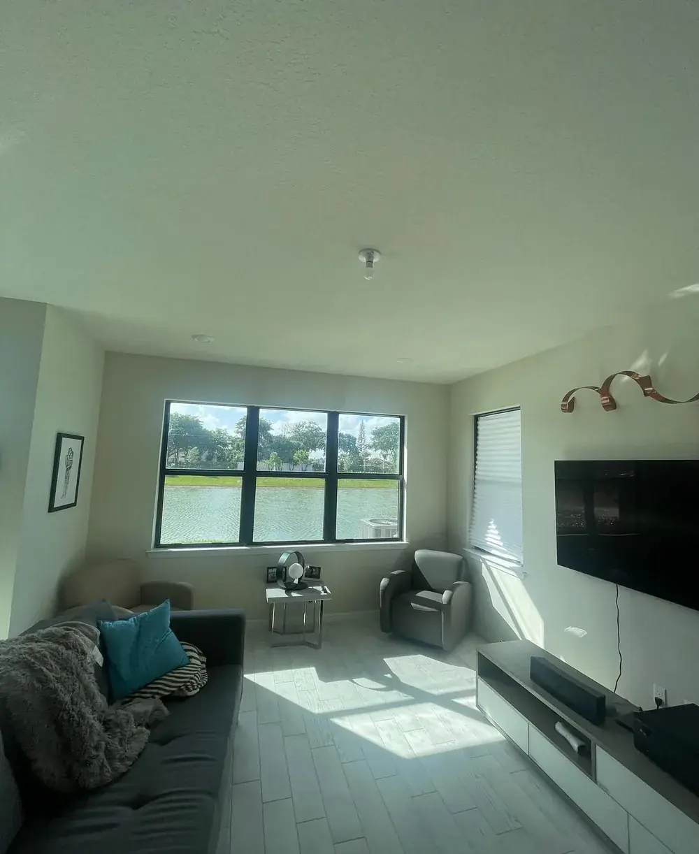 Living room ceiling with a small flush-mount light fixture before ceiling fan installation
