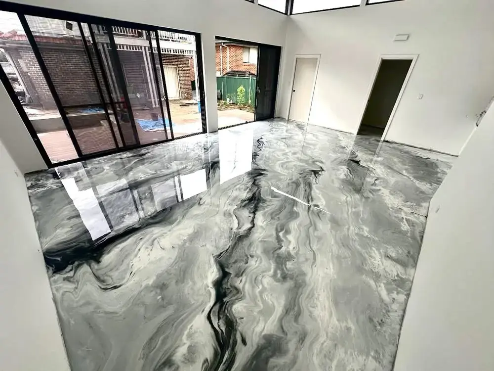 Metallic epoxy floor coating in charcoal and white marbled finish across an open room