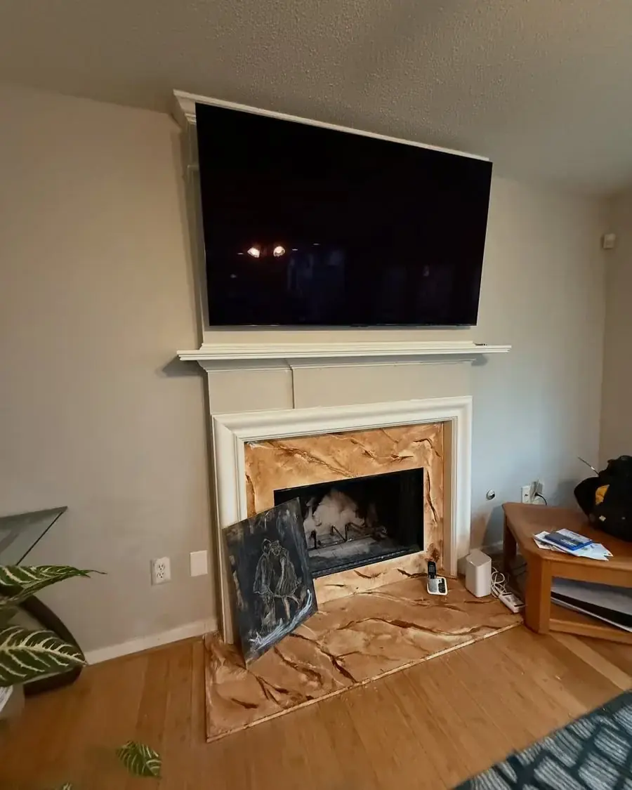 TV mounted above a fireplace mantle ready for the hearth surround to be finished