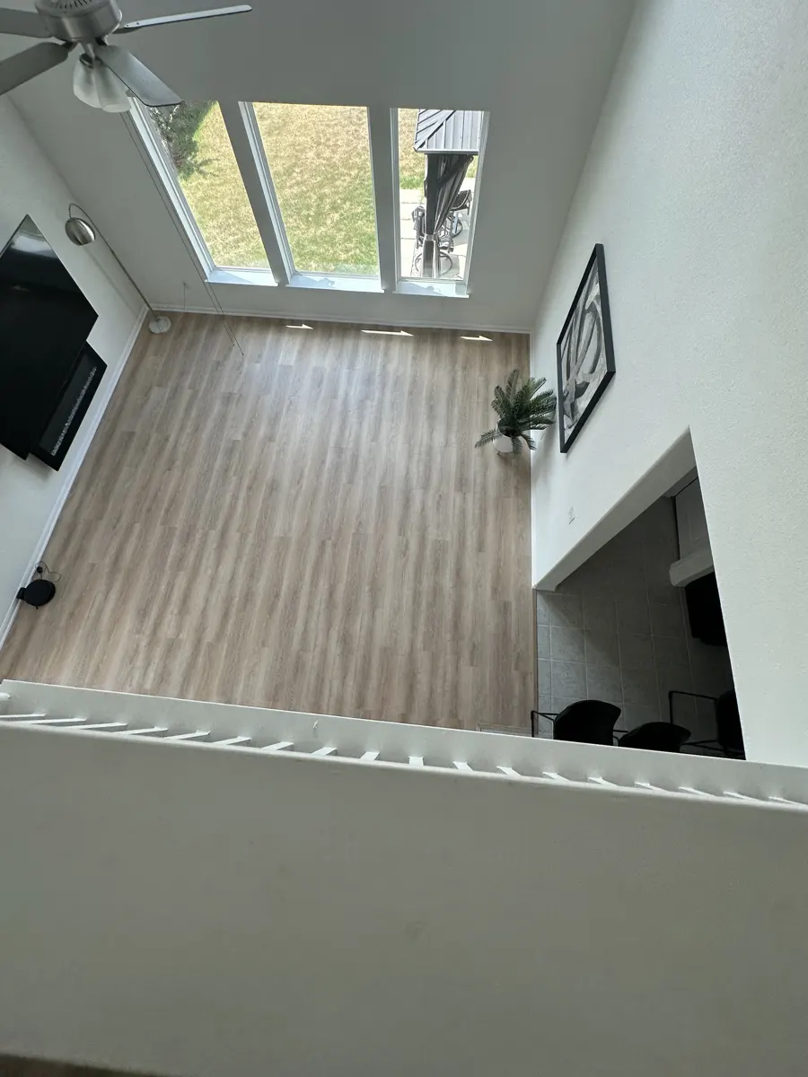 Two-story living room finished with light wood-look vinyl plank