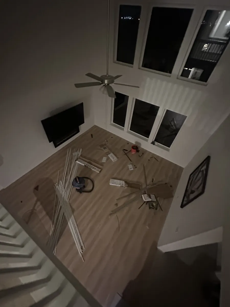 Two-story living room mid-install with flooring and trim laid out