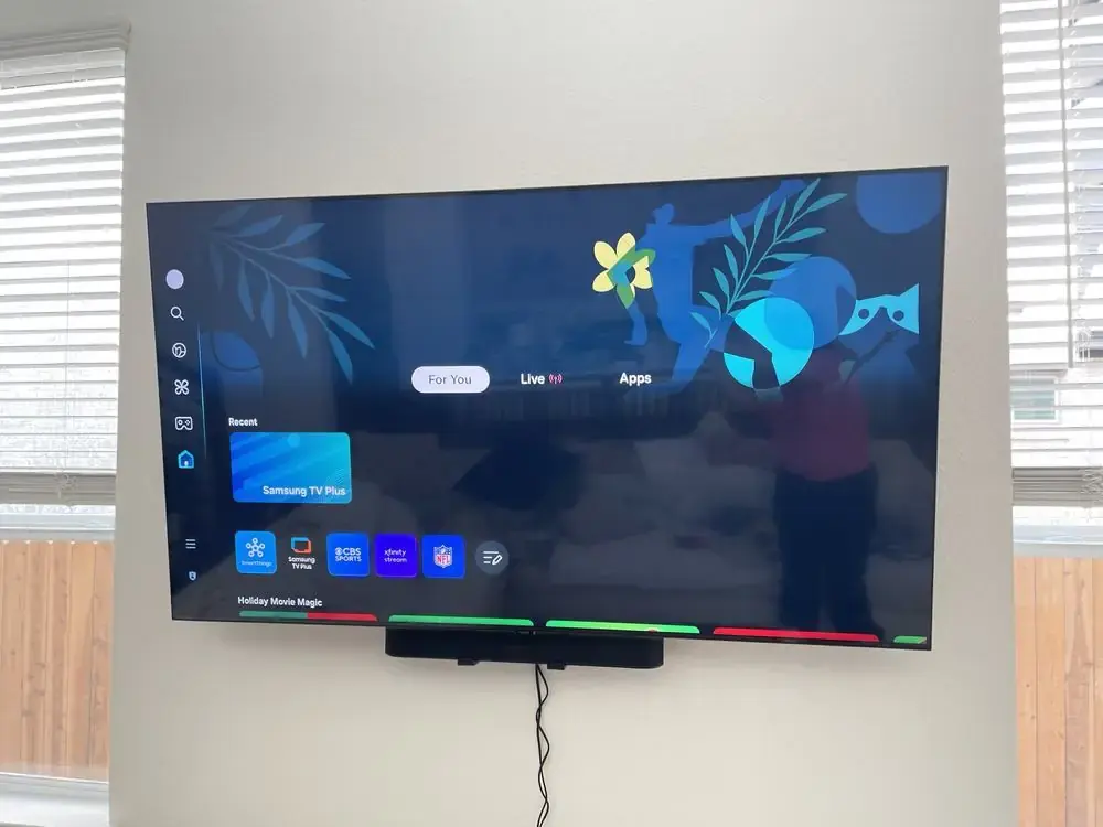 TV mounted on a full-motion articulating arm in a two-story living room with a staircase