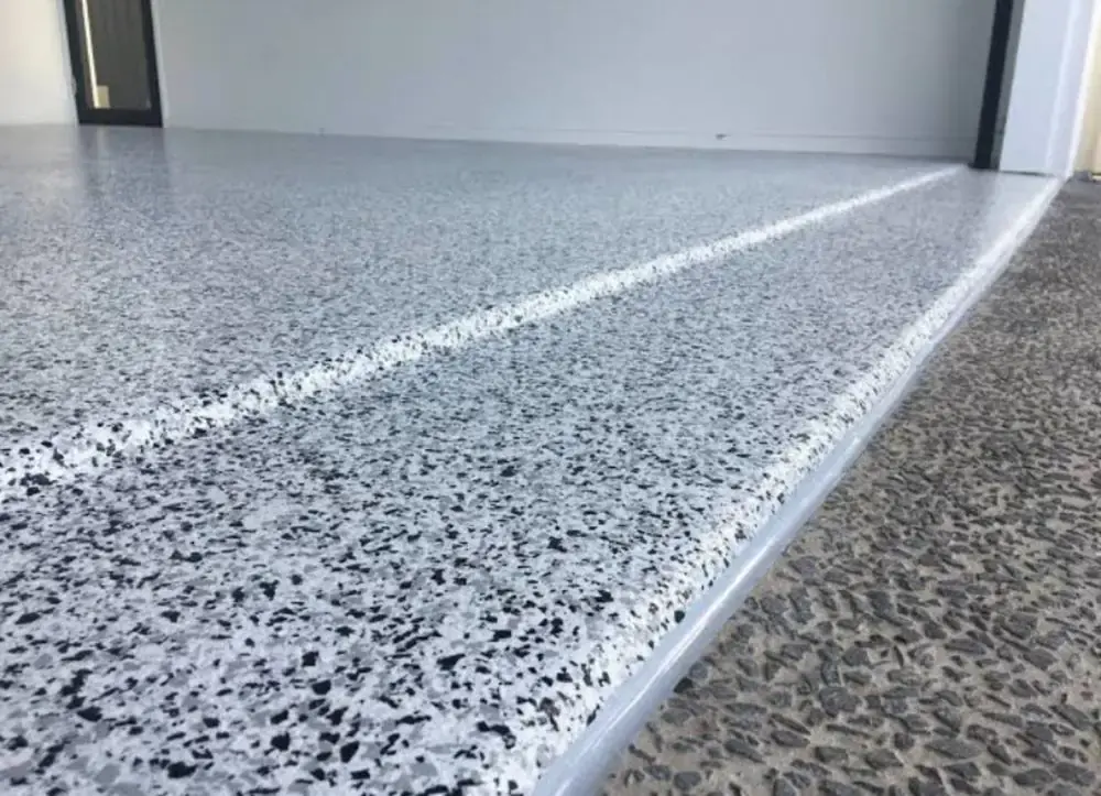 Flake chip epoxy garage floor coating with control joint line leading to the garage door