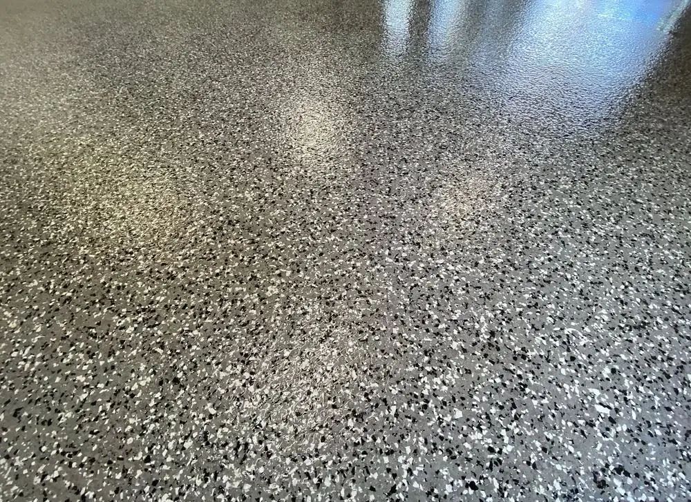 Close-up of gray, black, and white flake chip epoxy floor coating texture