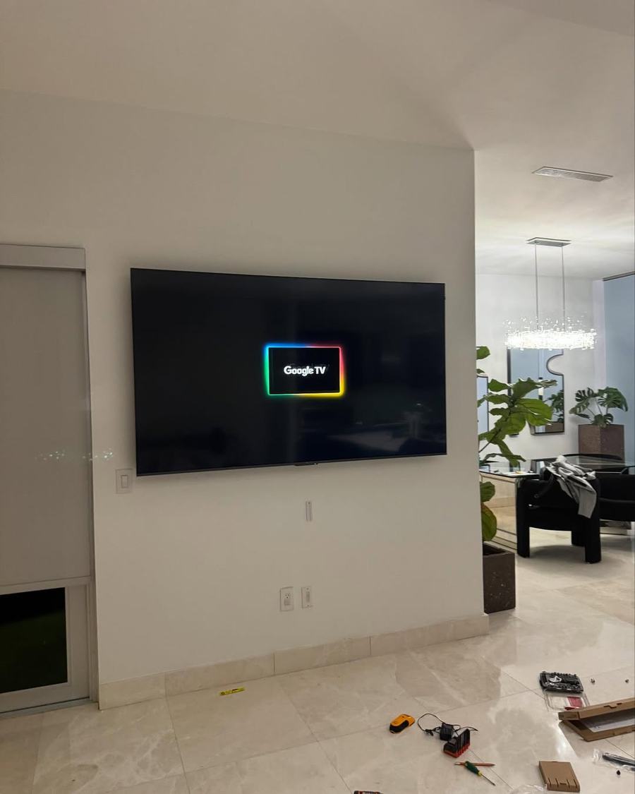 TV mounted flush on a great room wall with marble flooring, wires hidden