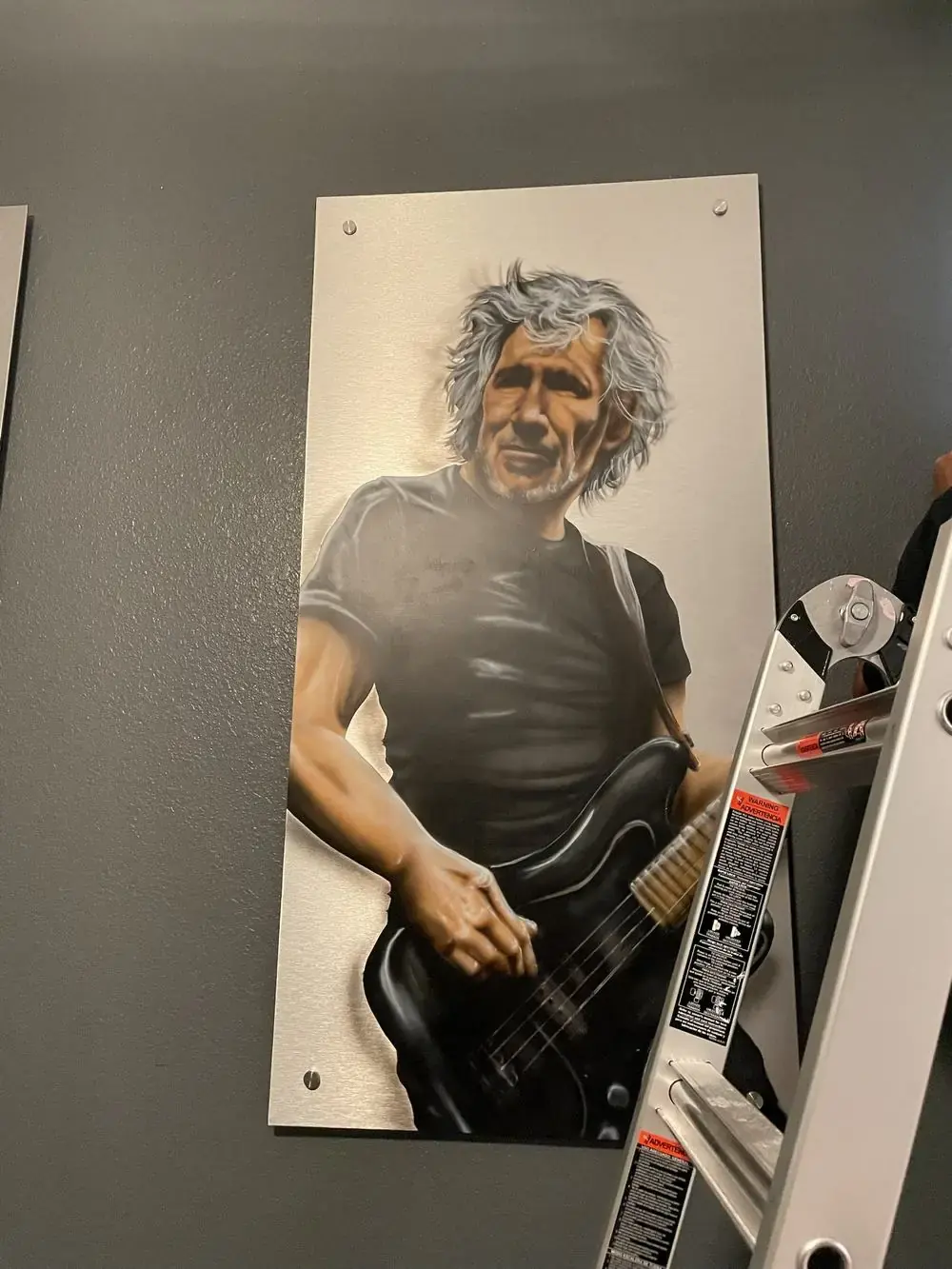 Close-up of a printed guitarist portrait art panel mounted on standoffs