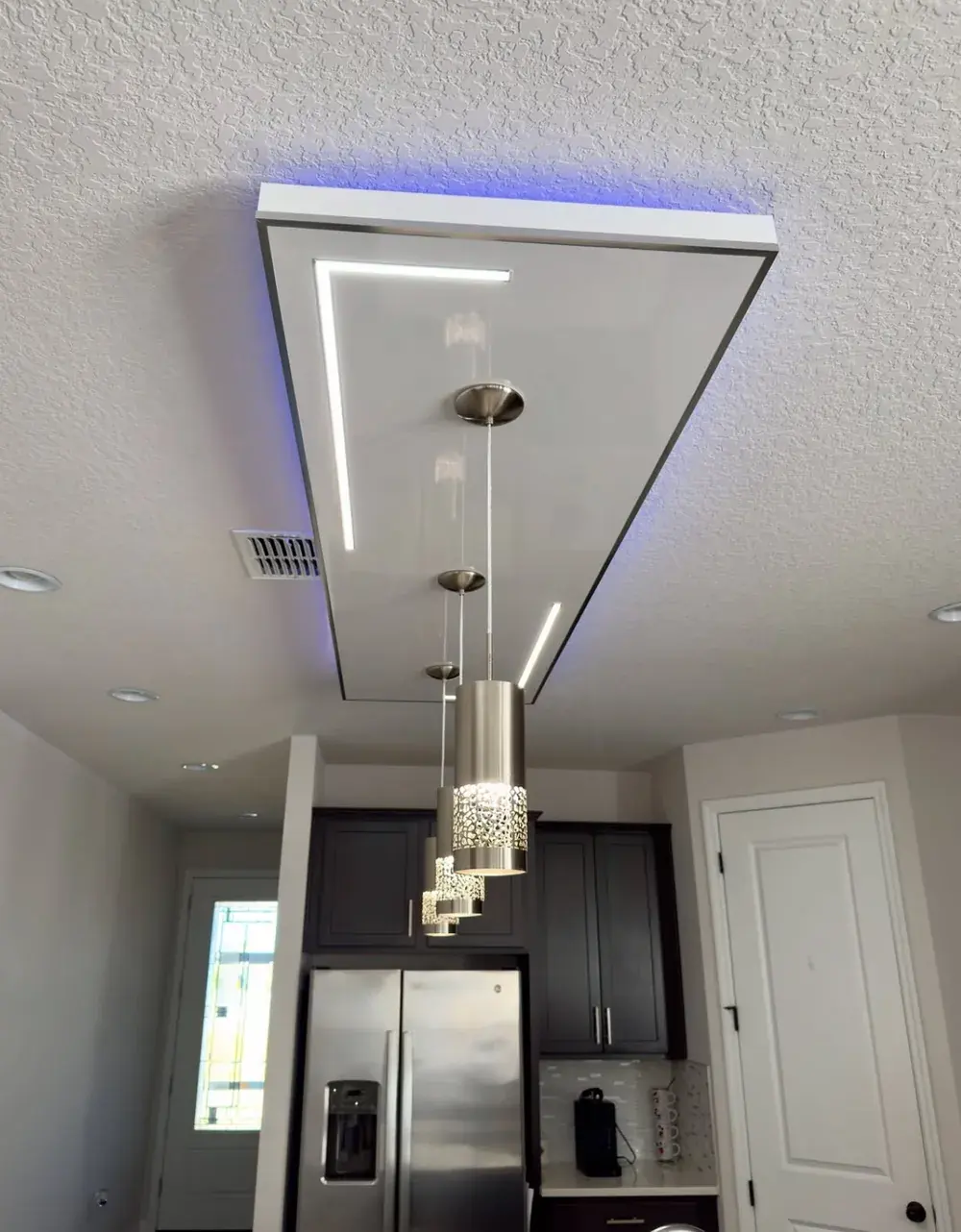 Kitchen ceiling light feature with pendant lights hung over the island, viewed from the kitchen