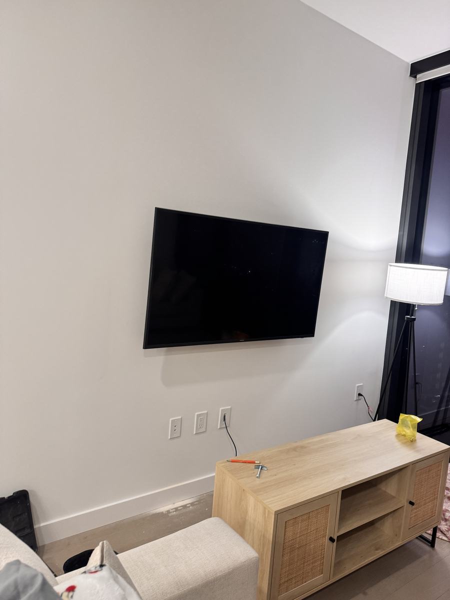TV mounted flush above a media console with wires hidden, South Austin apartment