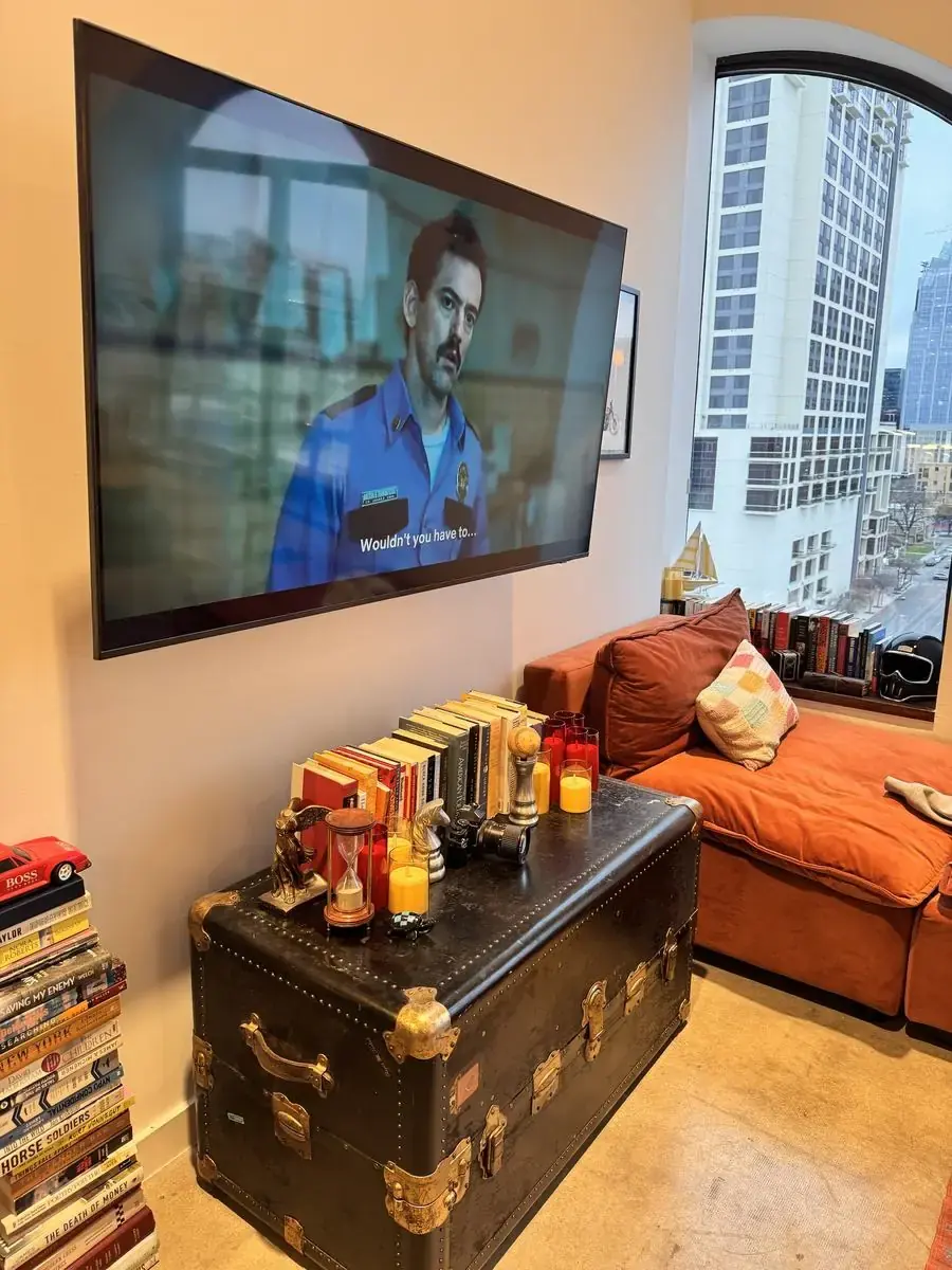 TV mounted with a clean finish in a downtown Austin condo with a skyline view